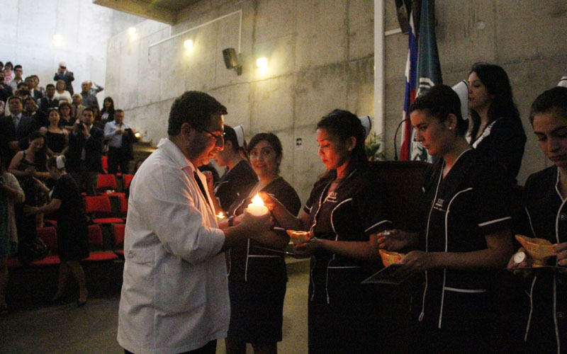 Director de Escuela, Rodrigo Ardiles, enciende las lámparas de las alumnas durante el acto.